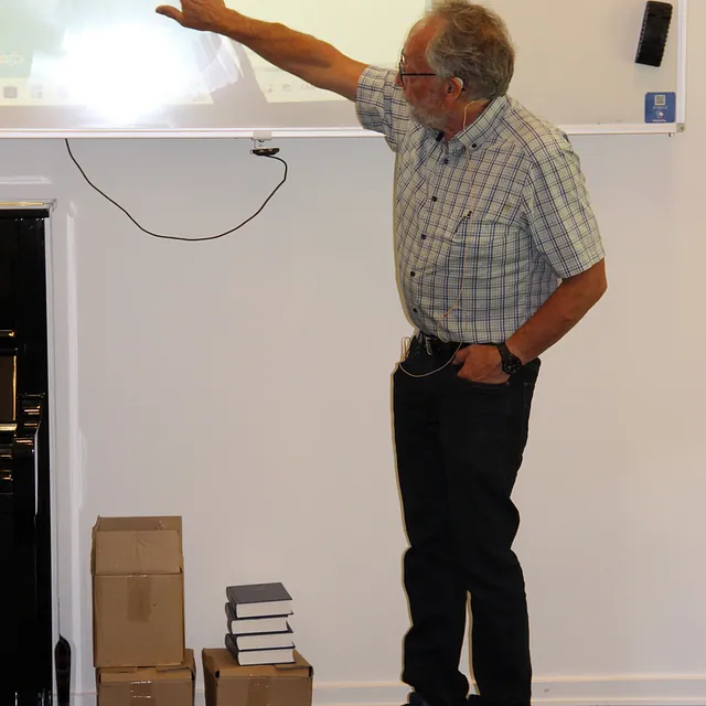 Mand peger på et kort projiceret på en whiteboardtavle.
