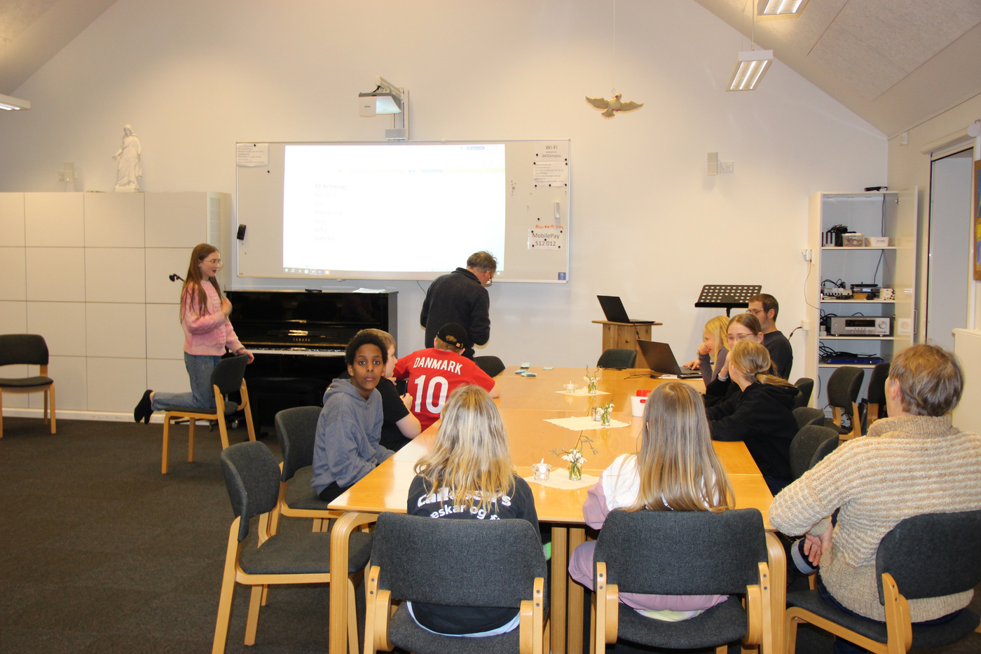  Forskellig gruppe unge og voksne i et kirkeligt mødelokale.