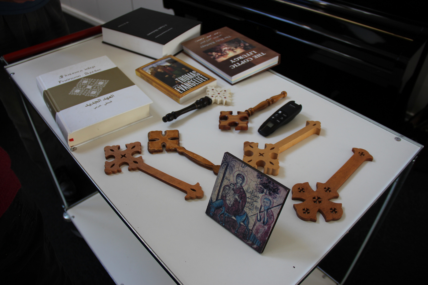 Forskellige kristne genstande, bøger og trækors på et bord.