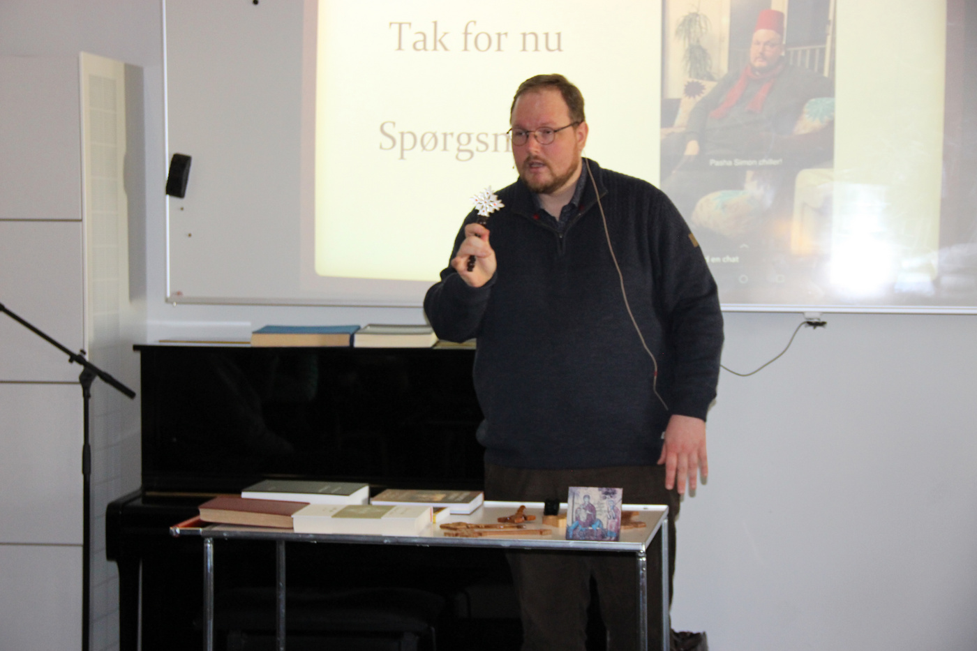 Mand præsenterer, holder en genstand, med 